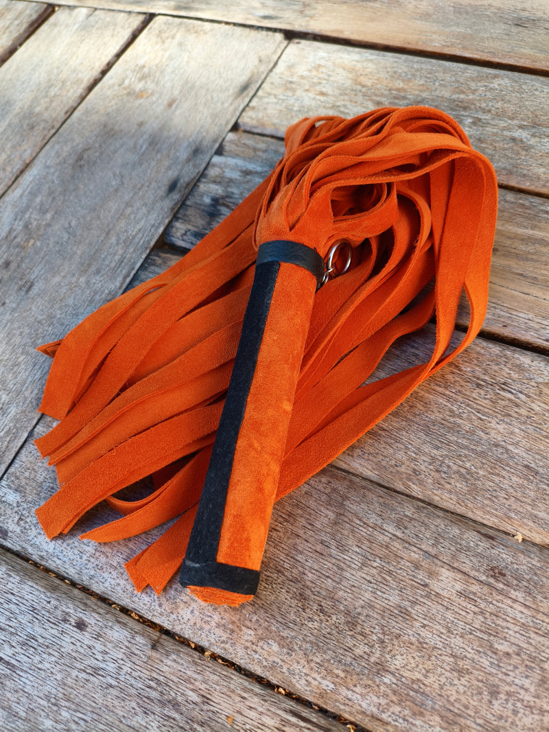 Martinet en cuir orange AdryX replié, poignée bordée de noir et anneau métallique