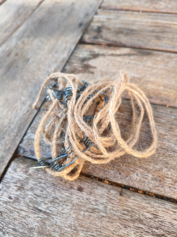 Cordon de jute barbelé AdryX de 2,2 m enroulé sur une table en bois, cilice artisanal