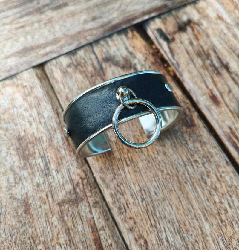 Profil du bracelet manchette en cuir noir AdryX, anneau argenté au centre de la bande de cuir