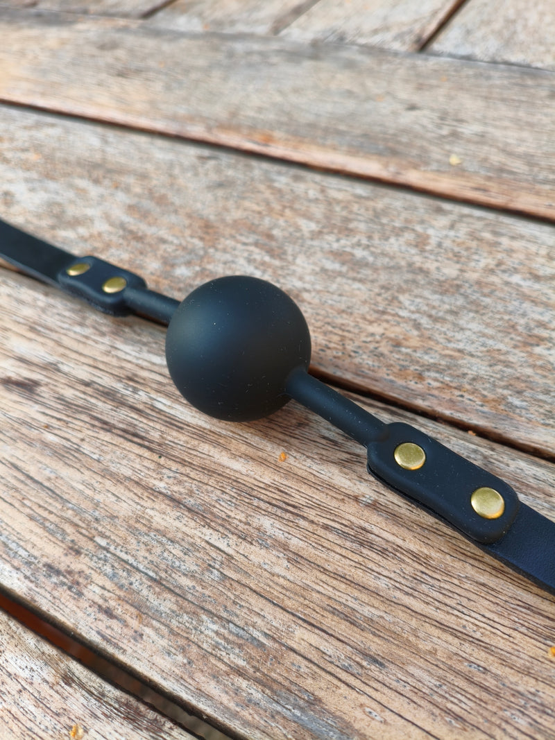 Bâillon boule en silicone et sangle en cuir noir AdryX, rivets en laiton, monté main en France