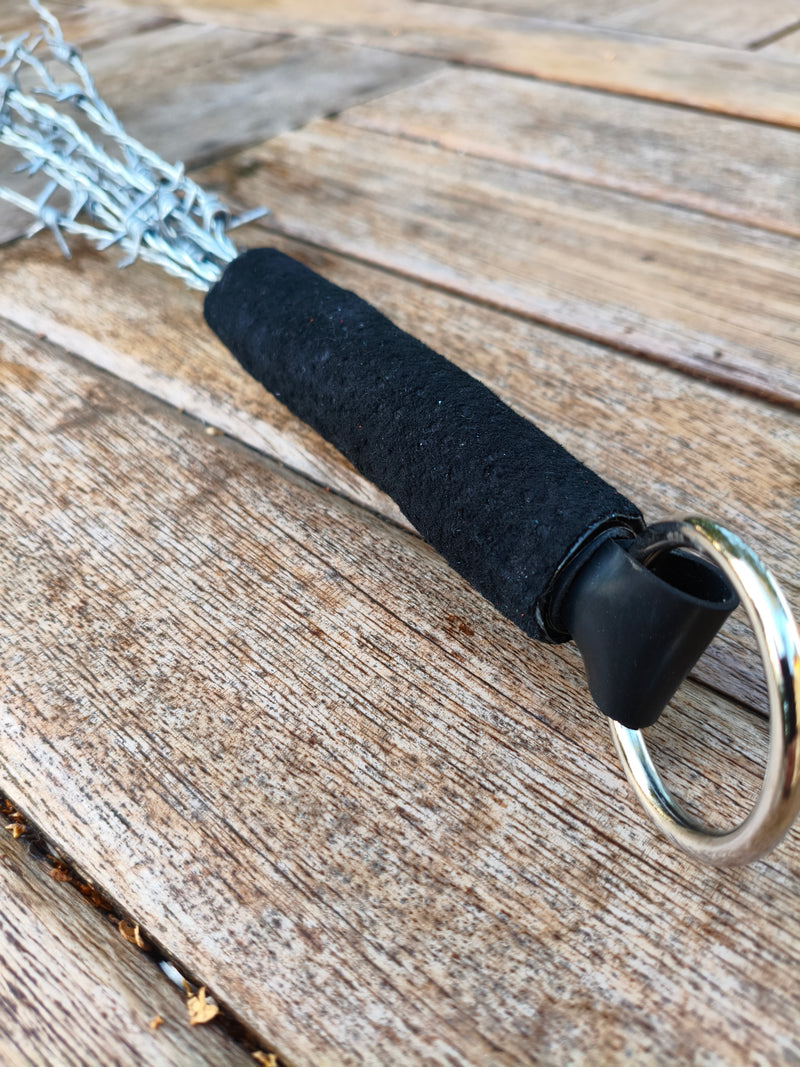 Détail du manche gainé noir et de l'anneau métallique du martinet en barbelés AdryX, fait main en France