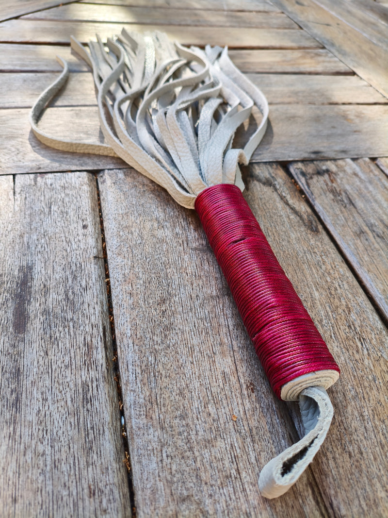 Martinet bicolore gris et rouge AdryX, manche rouge et dragonne au premier plan