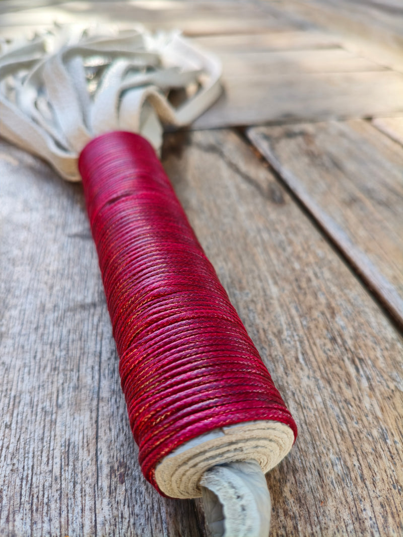 Détail du manche ligaturé de cuir rouge du martinet bicolore AdryX, fait main en France