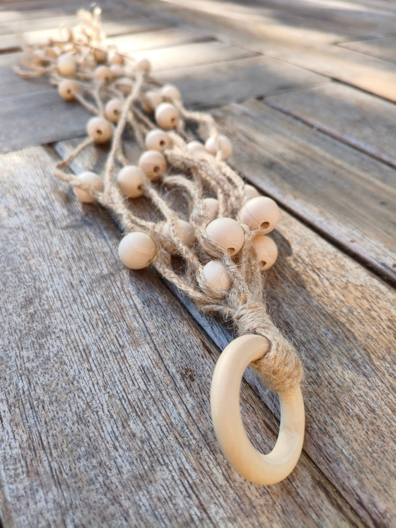 Anneau en bois et poignée ligaturée du martinet en jute AdryX au premier plan