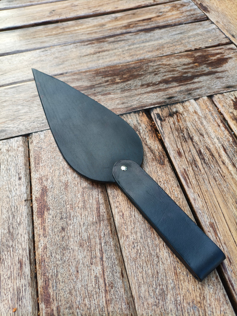 Paddle AdryX « La Plume de Minuit » en cuir noir, 40 cm, vu en entier sur une table en bois