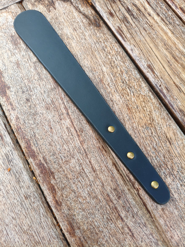 Paddle BDSM AdryX en cuir noir double couche, 31 cm, vu en entier sur une table en bois